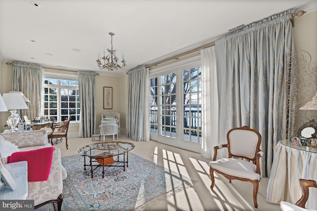 carpeted living room with a notable chandelier