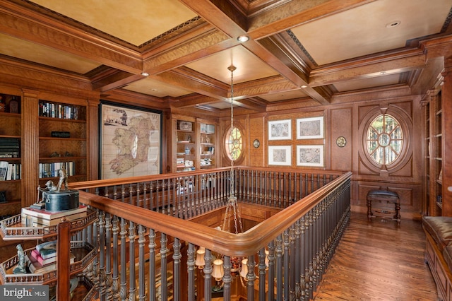 hall with coffered ceiling, dark wood-type flooring, beamed ceiling, crown molding, and built in shelves