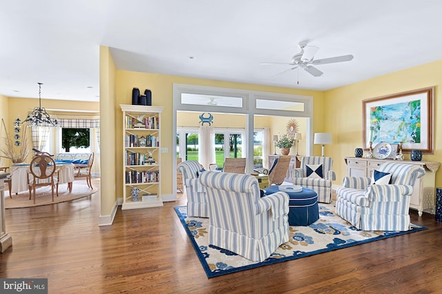 living room with french doors, wood-type flooring, and ceiling fan with notable chandelier