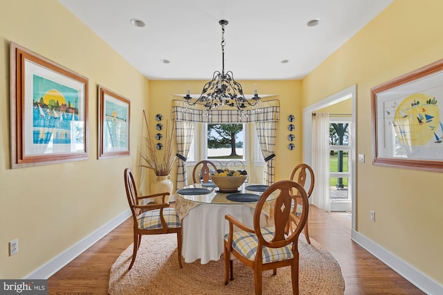 dining area with a notable chandelier and hardwood / wood-style flooring