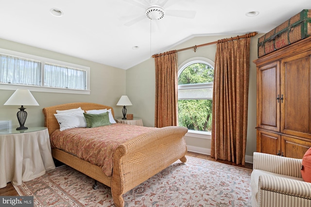 bedroom with ceiling fan, vaulted ceiling, and light hardwood / wood-style flooring