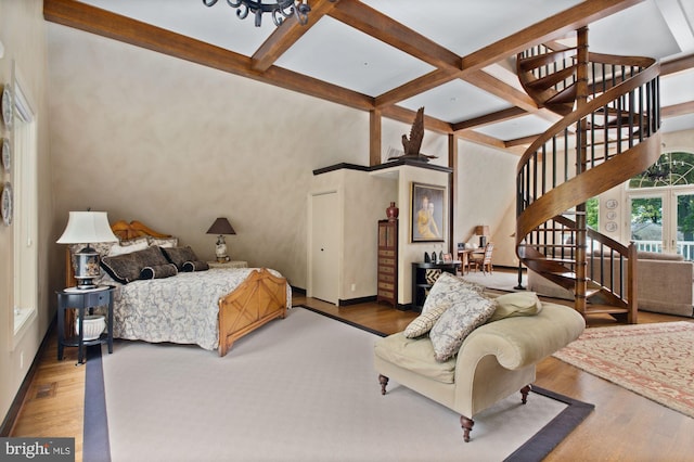 bedroom featuring coffered ceiling, dark wood-type flooring, french doors, and beam ceiling