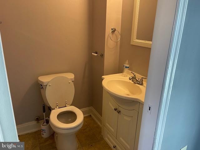 bathroom with tile flooring, large vanity, and toilet