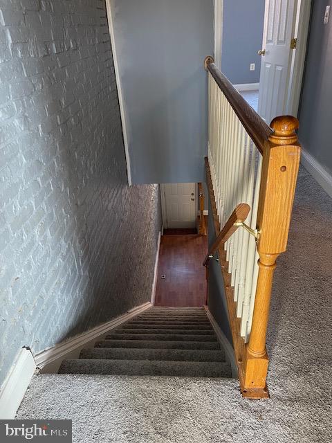 stairs featuring dark colored carpet