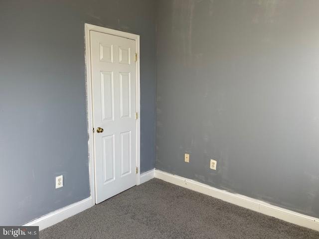 empty room with dark colored carpet