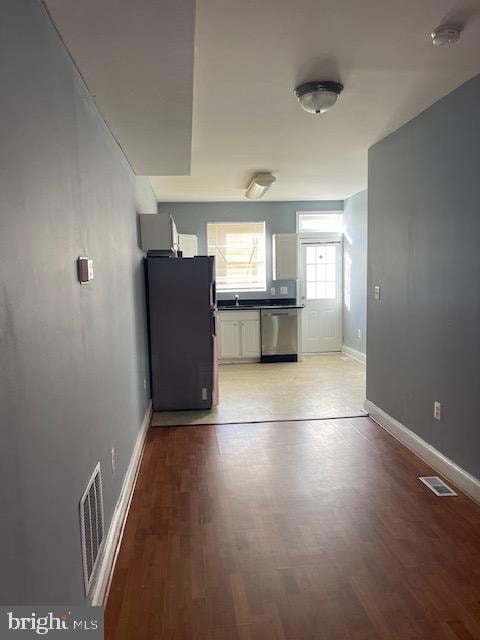 kitchen with dishwasher, light hardwood / wood-style floors, and black refrigerator