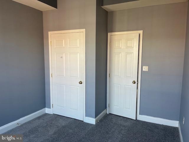 unfurnished bedroom featuring dark carpet