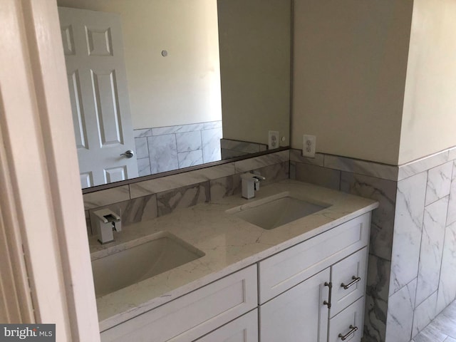 bathroom with tile walls and dual bowl vanity