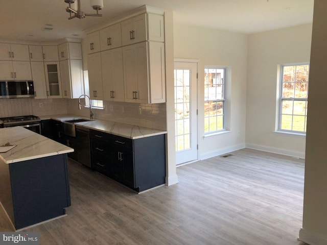 kitchen with white cabinetry, light hardwood / wood-style flooring, appliances with stainless steel finishes, and sink