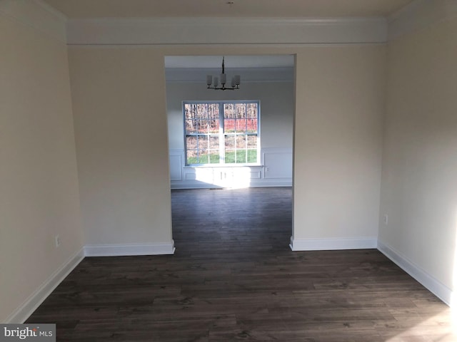 spare room featuring an inviting chandelier and dark hardwood / wood-style flooring