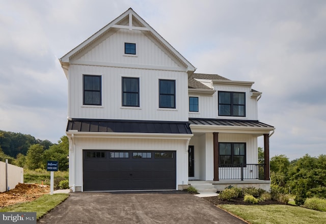 modern inspired farmhouse featuring covered porch and a garage