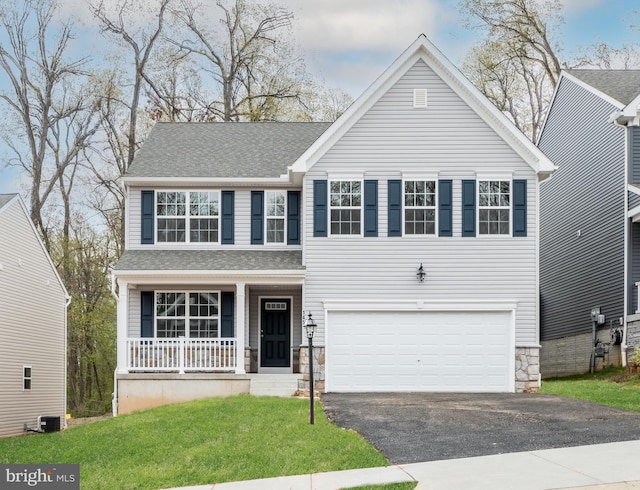 view of front of home with central AC unit, a front lawn, covered porch, and a garage