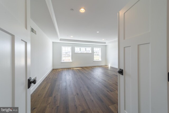 empty room with a tray ceiling and dark wood-type flooring