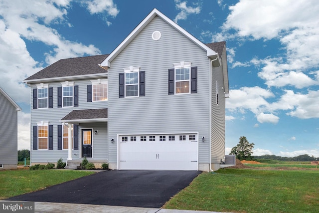 view of front of property with a garage, central AC, and a front lawn