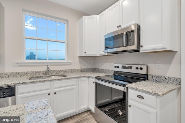 kitchen with sink, white cabinets, and appliances with stainless steel finishes