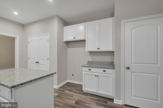 kitchen featuring white cabinetry, light stone counters, dark wood-type flooring, and a kitchen island