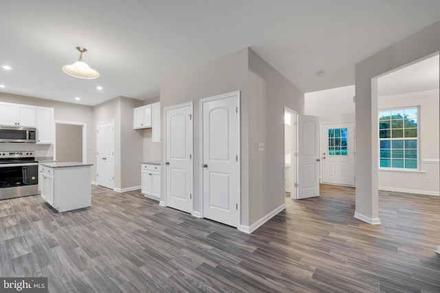 kitchen with white cabinetry, appliances with stainless steel finishes, and dark hardwood / wood-style flooring