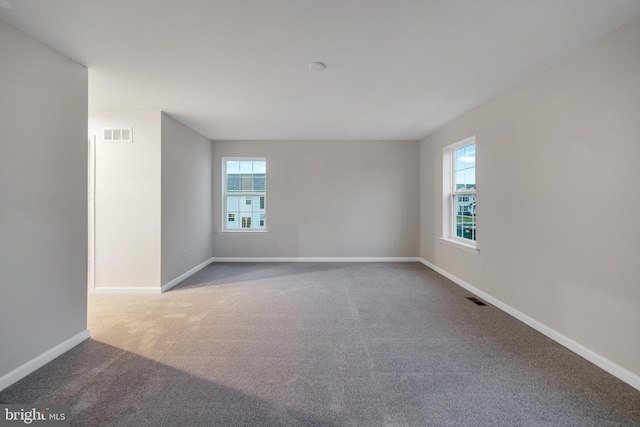 carpeted spare room featuring plenty of natural light