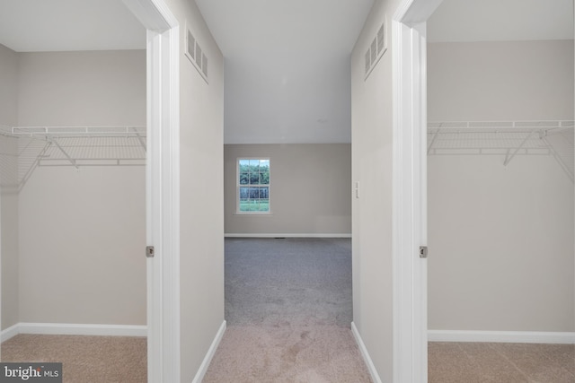 spacious closet featuring light carpet