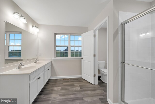 bathroom featuring plenty of natural light, an enclosed shower, and toilet