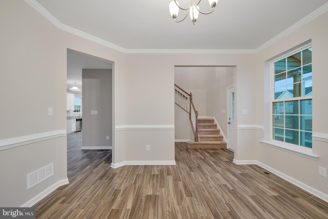 unfurnished room with crown molding, a notable chandelier, and hardwood / wood-style flooring