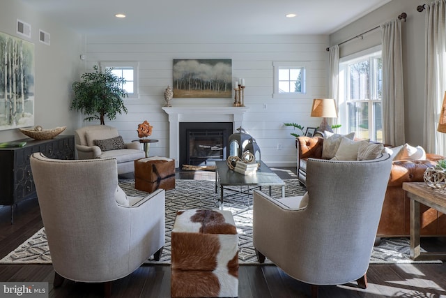 living room with a wealth of natural light and dark wood-type flooring