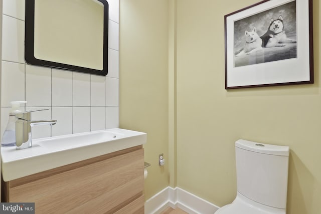 bathroom featuring backsplash, toilet, and vanity