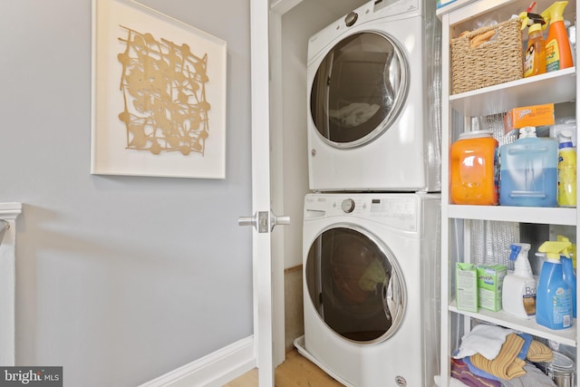 clothes washing area with stacked washer / dryer and light hardwood / wood-style flooring