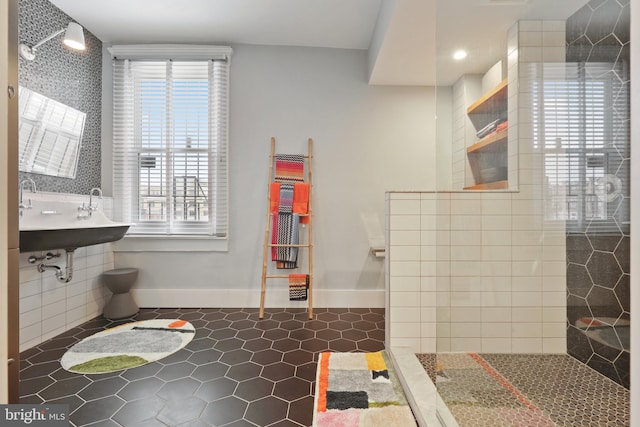 bathroom featuring sink, tiled shower, tile floors, and tile walls