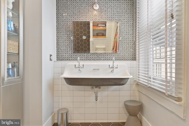 bathroom featuring tile walls, tile flooring, and sink