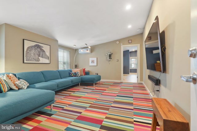 living room with a wealth of natural light and a wall unit AC