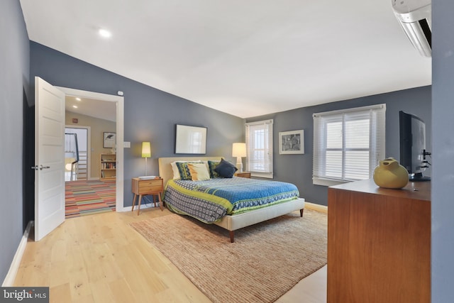 bedroom with vaulted ceiling and light wood-type flooring