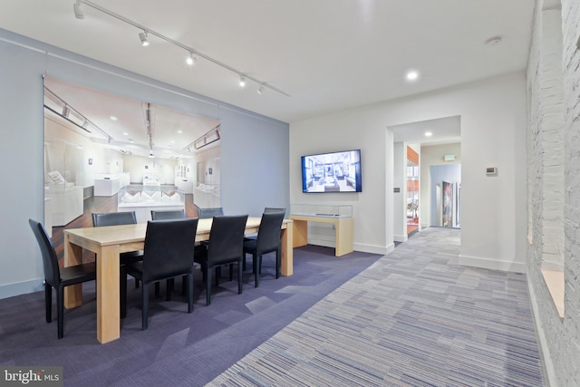 carpeted dining room with track lighting