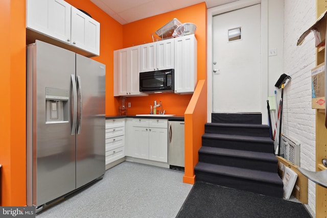 kitchen with stainless steel fridge, sink, white cabinetry, and dishwasher