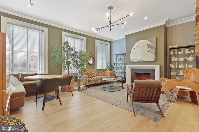 sitting room with a notable chandelier, crown molding, and light hardwood / wood-style flooring