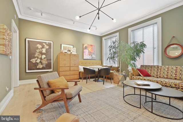 living area featuring a chandelier, rail lighting, and crown molding