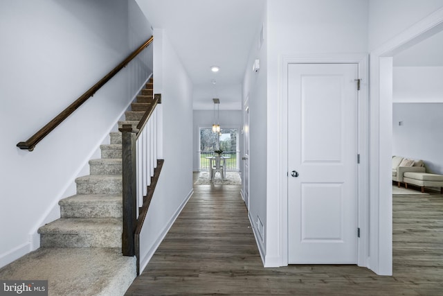 interior space with dark wood-type flooring and a chandelier