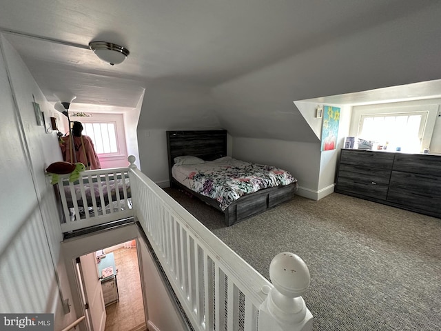 carpeted bedroom with vaulted ceiling and multiple windows