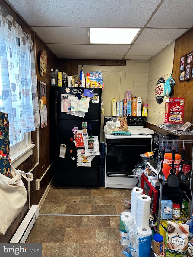 interior space featuring a paneled ceiling, wood walls, dark tile flooring, and a baseboard heating unit