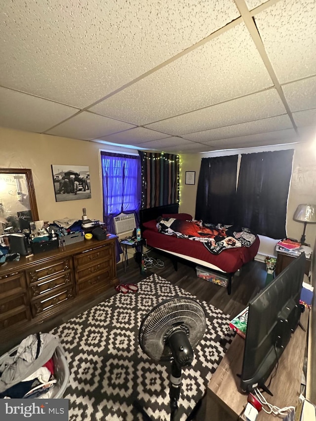 bedroom featuring a drop ceiling and hardwood / wood-style flooring