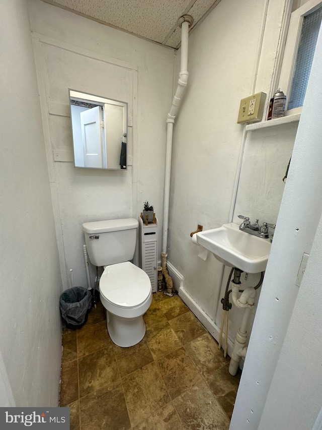 bathroom featuring sink, tile floors, and toilet