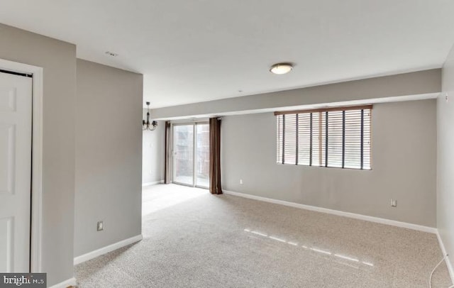 carpeted empty room with a chandelier