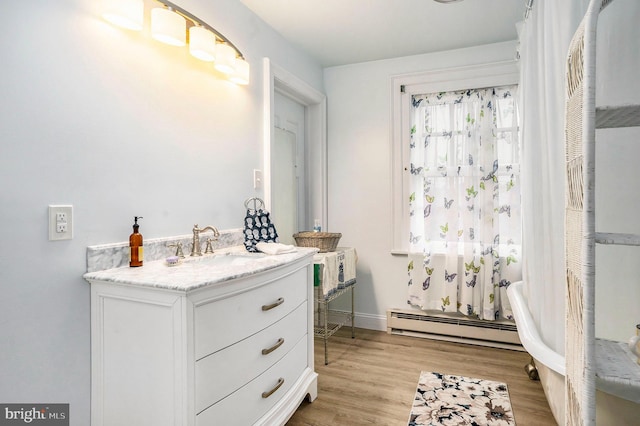 bathroom featuring vanity, hardwood / wood-style flooring, and a baseboard heating unit