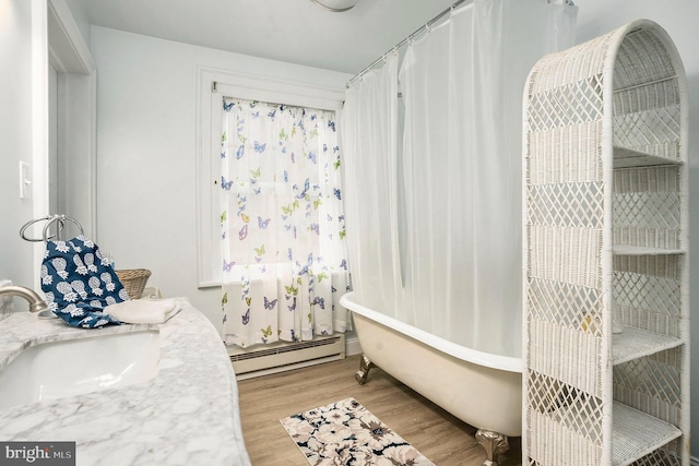 bathroom featuring a baseboard radiator, sink, and hardwood / wood-style floors