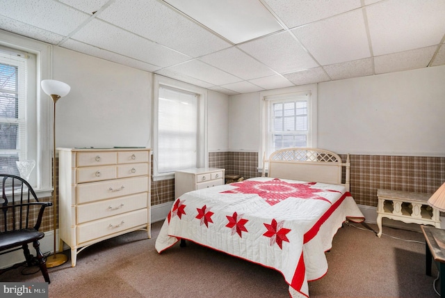 bedroom featuring dark carpet and a drop ceiling