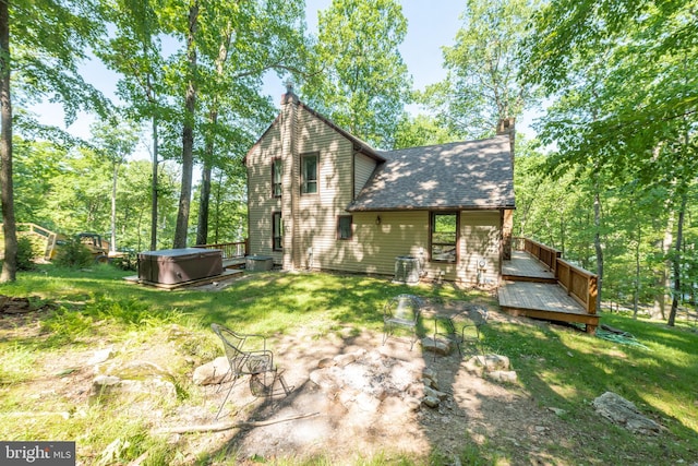 view of yard with a deck and a hot tub