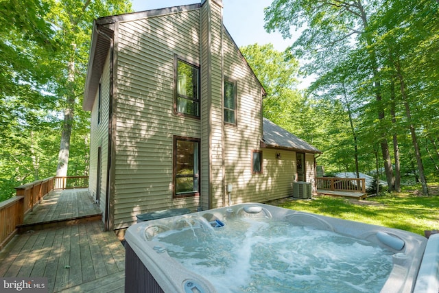 deck with central air condition unit and an outdoor hot tub