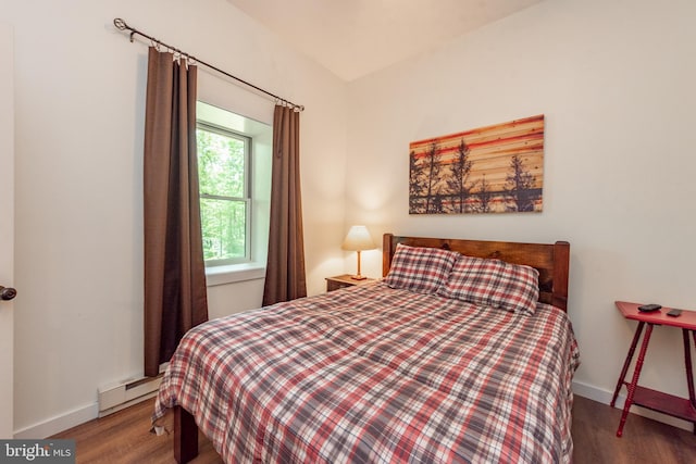 bedroom featuring a baseboard heating unit and dark wood-type flooring