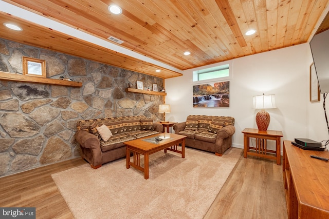 living room with a stone fireplace, wooden ceiling, and light wood-type flooring