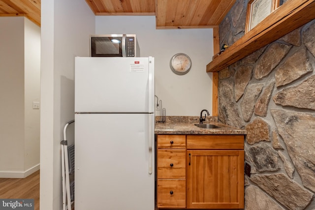 kitchen with wood ceiling, light hardwood / wood-style flooring, white refrigerator, and sink